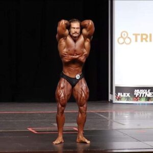 chris bumstead sul palco del mister olympia 2020 durante il pregara posa di addome e gambe